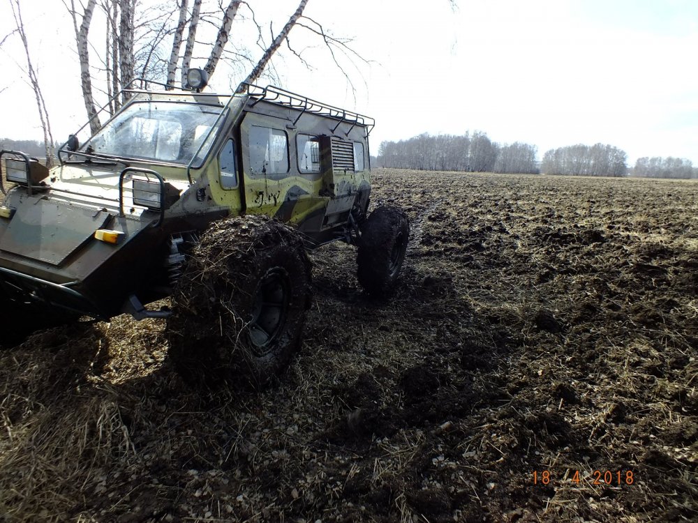 По пашне.